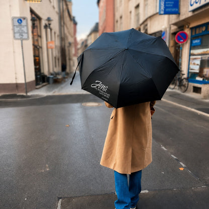Schwarzer Taschenschirm mit Jena Design in der Jenaer Innenstadt. Kompakter Regenschirm als Souvenir und Geschenk aus Jena.
